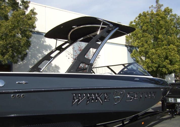 Malibu G3 Complete Bimini over boat tower, black fabric canopy with metal frame, mounted on a sleek gray boat.