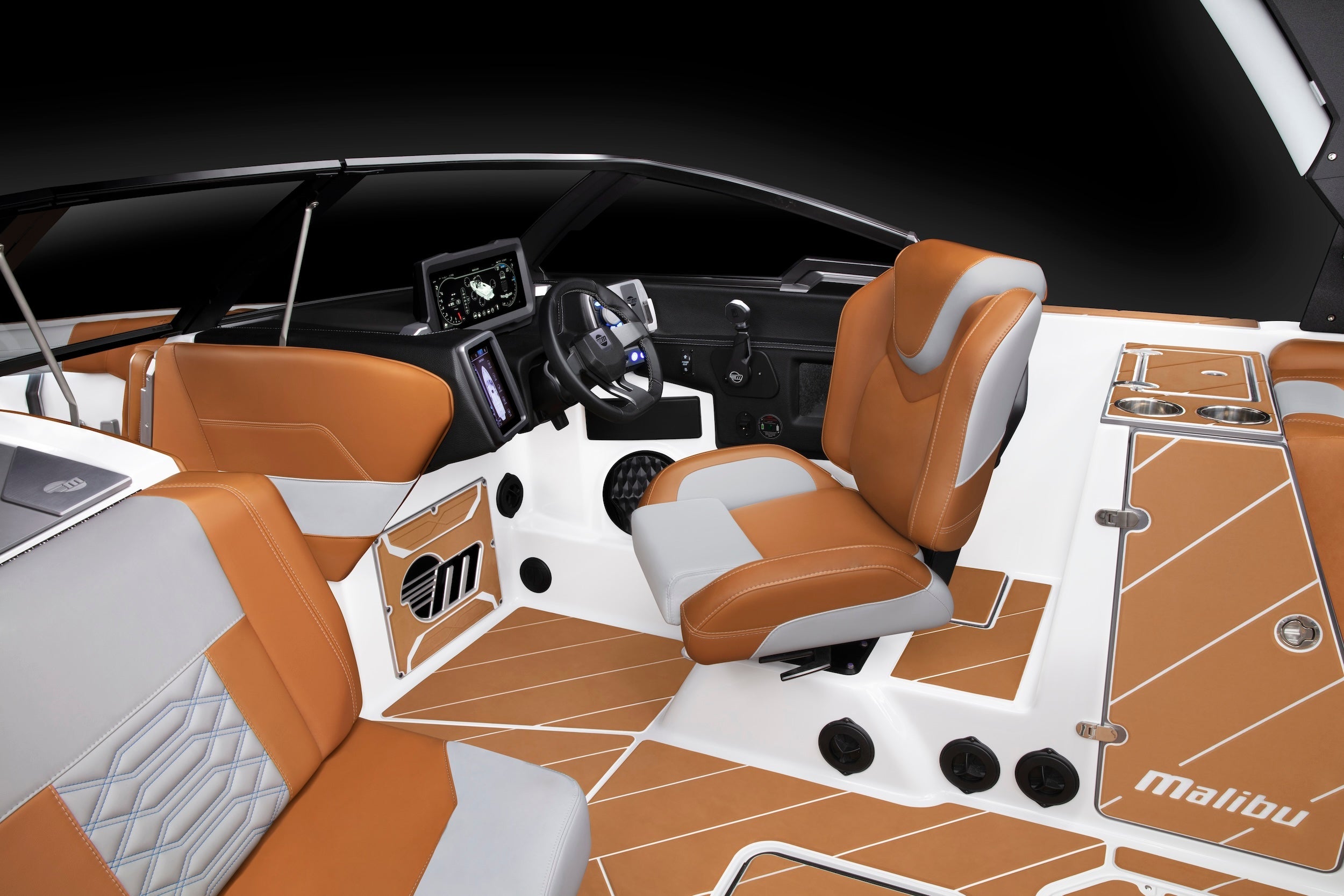 Interior view of a Malibu boat with tan and gray seating, dashboard, and windshield, designed for model HKLMNS, 2020-2022.