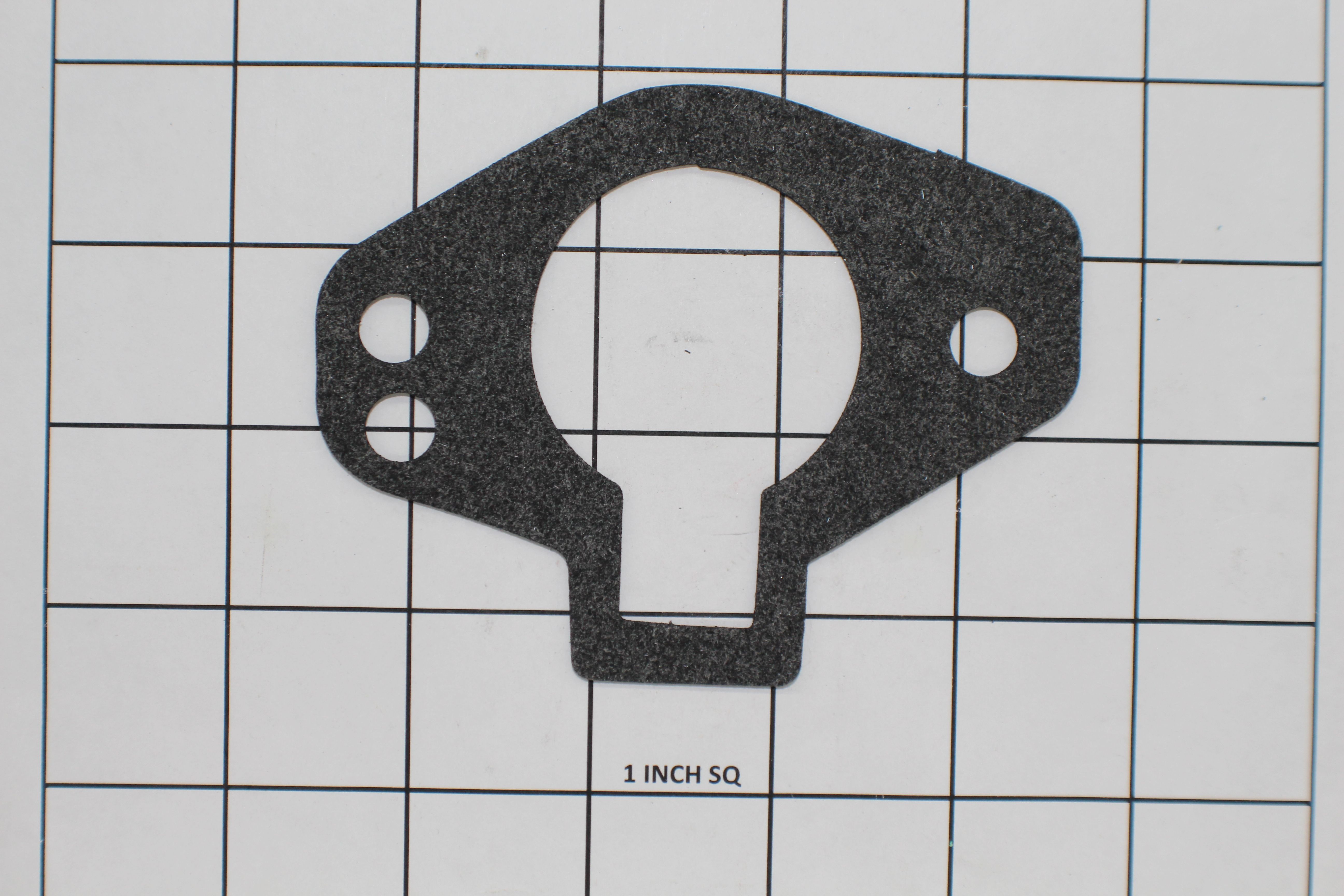 Black thermostat housing gasket with multiple holes, placed on a grid background for size reference.