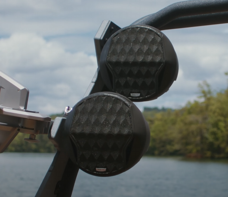 Malibu REV8 tower speakers, 22-24 inches, mounted outdoors near water, with black textured speaker grilles.