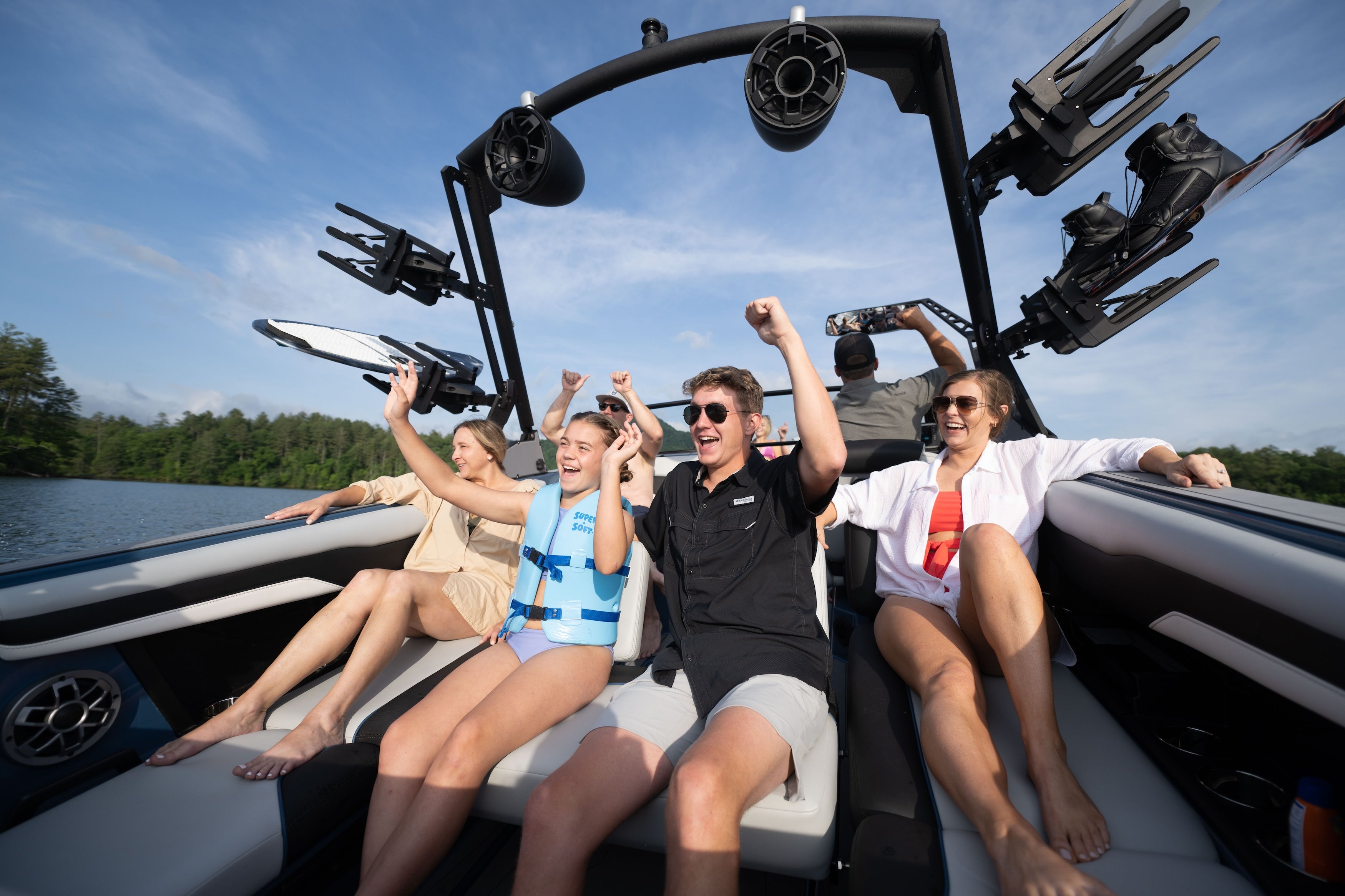 Group of friends enjoying a day on the water in an Axis AW20 boat, celebrating with excitement and joy.