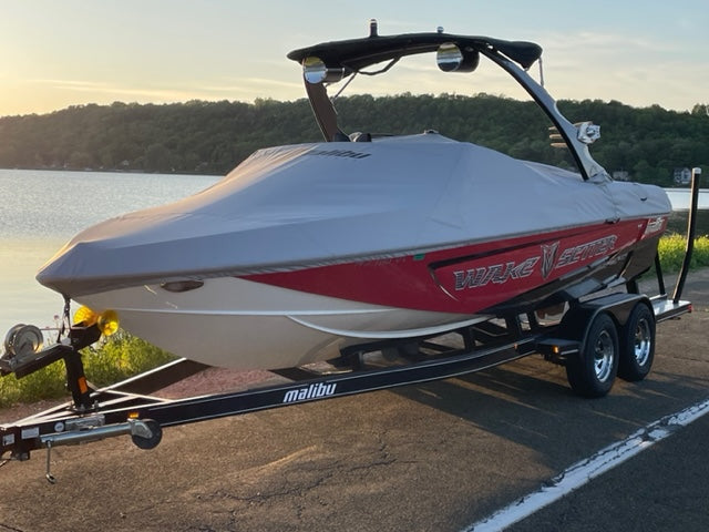 20ft Malibu boat cover for Illusion X/XS Tower, fitted on a boat on a trailer near a lake at sunset.