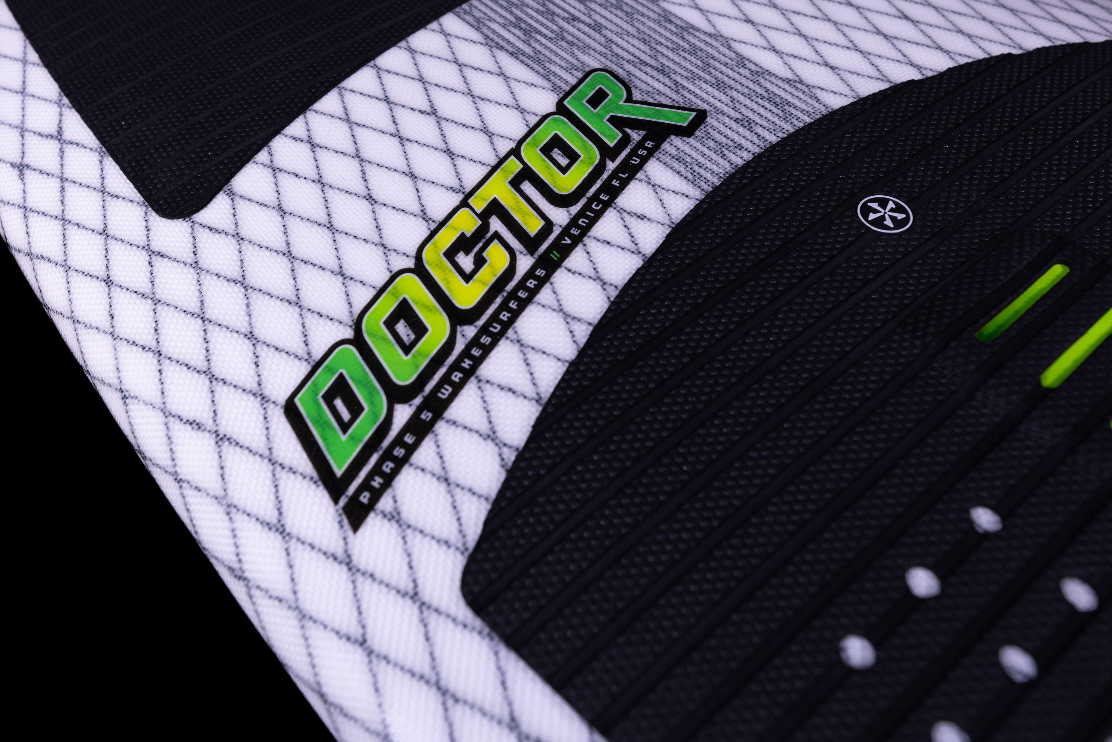 Close-up of the 2025 Phase 5 Doctor Surf Board featuring black and white textured surfaces with green and black branding.