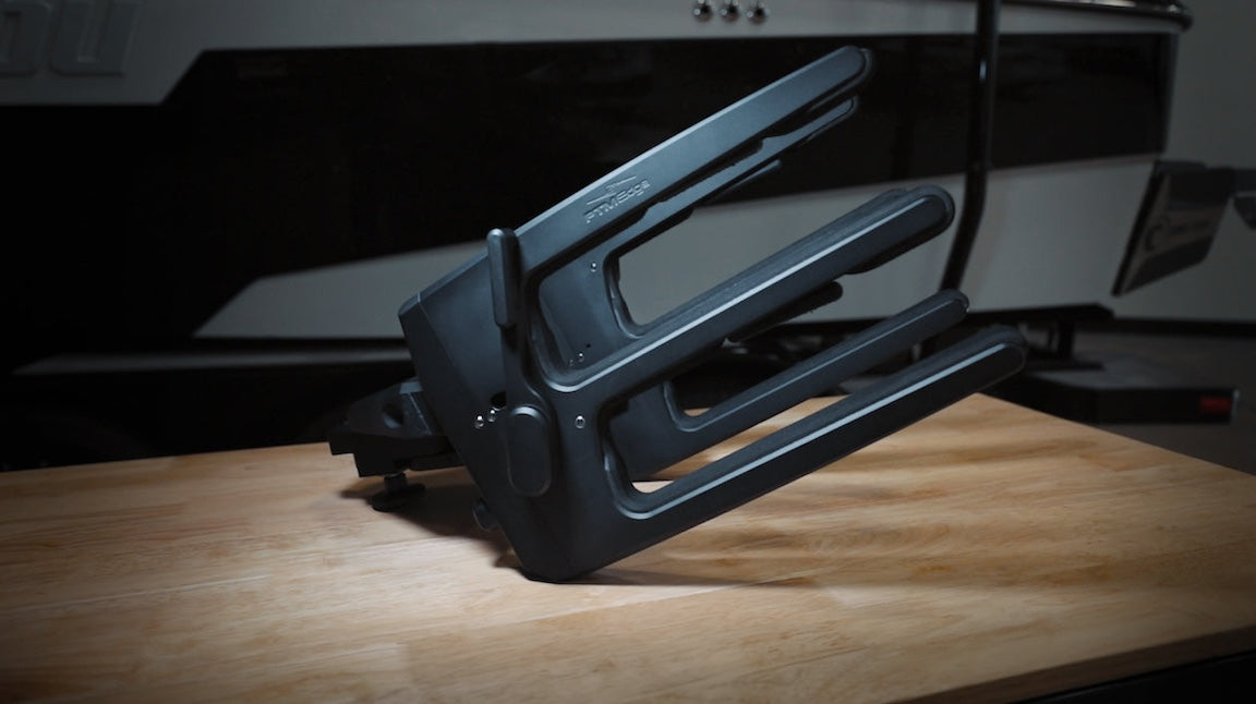 Axis PTM Gen 2 Clamping Racks, black, adjustable, mounted on a wooden surface, used for securing equipment or tools.