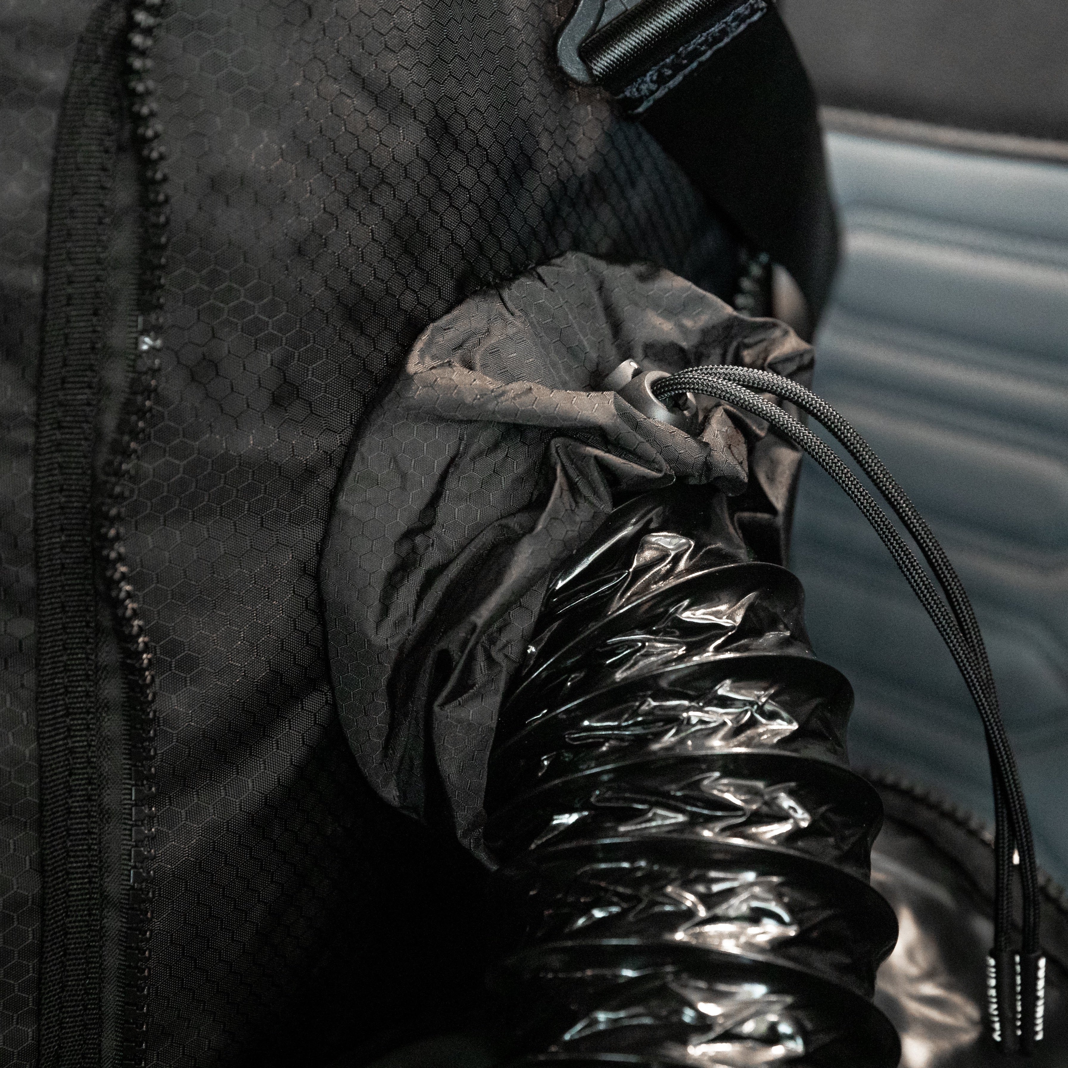 Black heated towel bag with a flexible hose and zipper, designed to keep towels warm and dry.