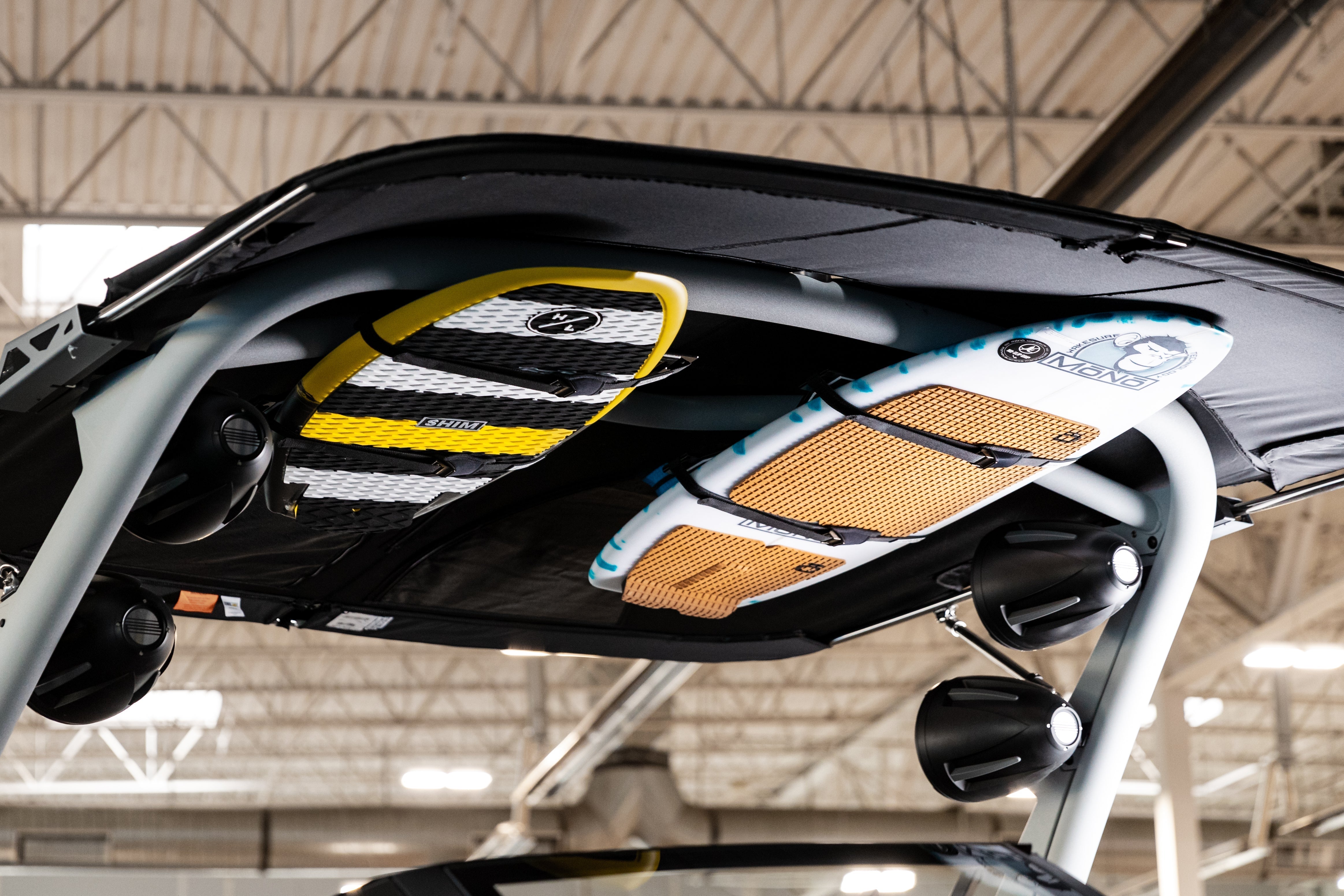 Surfboards secured on the XR1 Surf Rack with G3 & G5 Towers, mounted on a vehicle roof in an indoor setting.