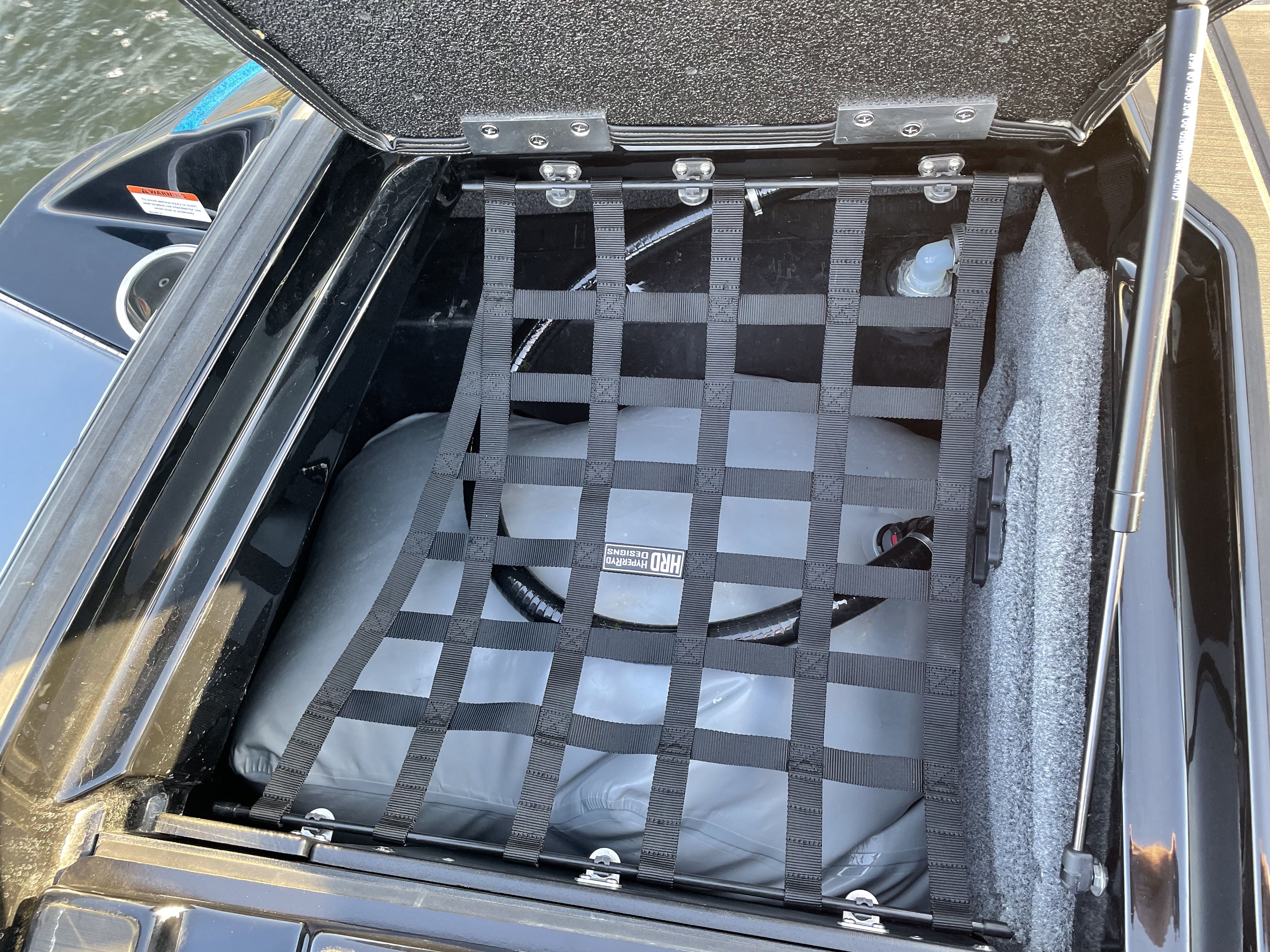 Pair of HRD Locker Nets with elastic straps securing a water tank inside a boat storage compartment.