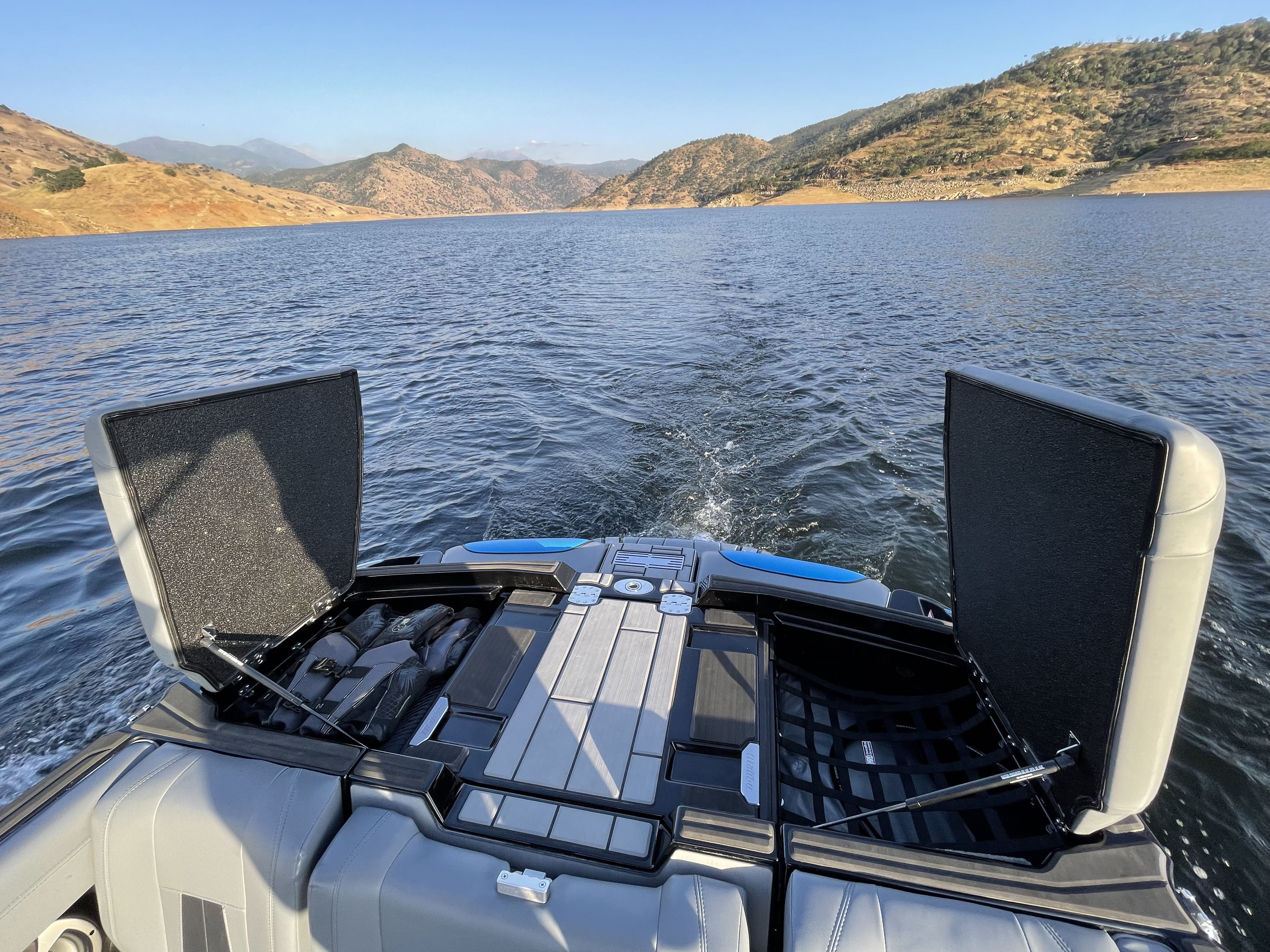 Pair of HRD Locker Nets installed on a boat, with open hatches, over a scenic lake and mountain landscape.