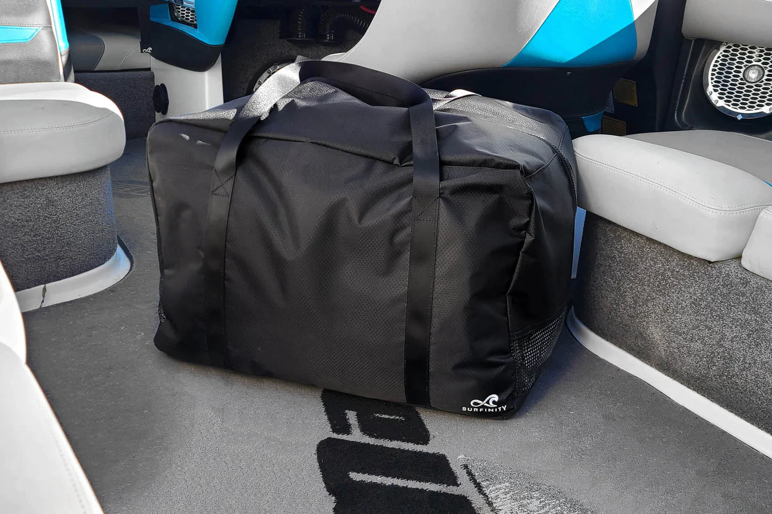 Black factory cover bag with handles, placed on a boat floor near seats and speakers.