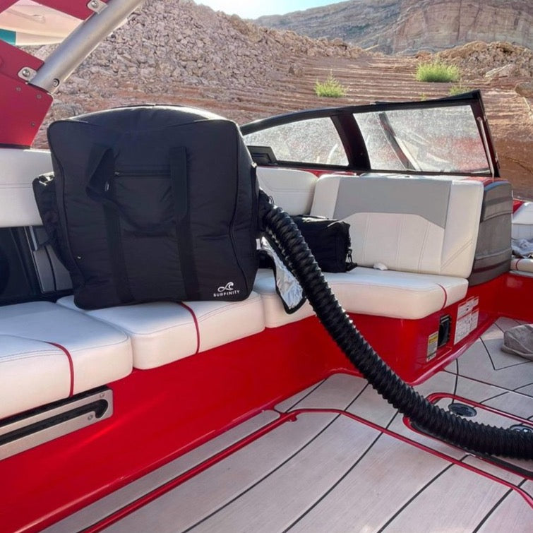 Heated towel bag on boat seat, connected to a hose, designed to keep towels warm and dry during outdoor activities.