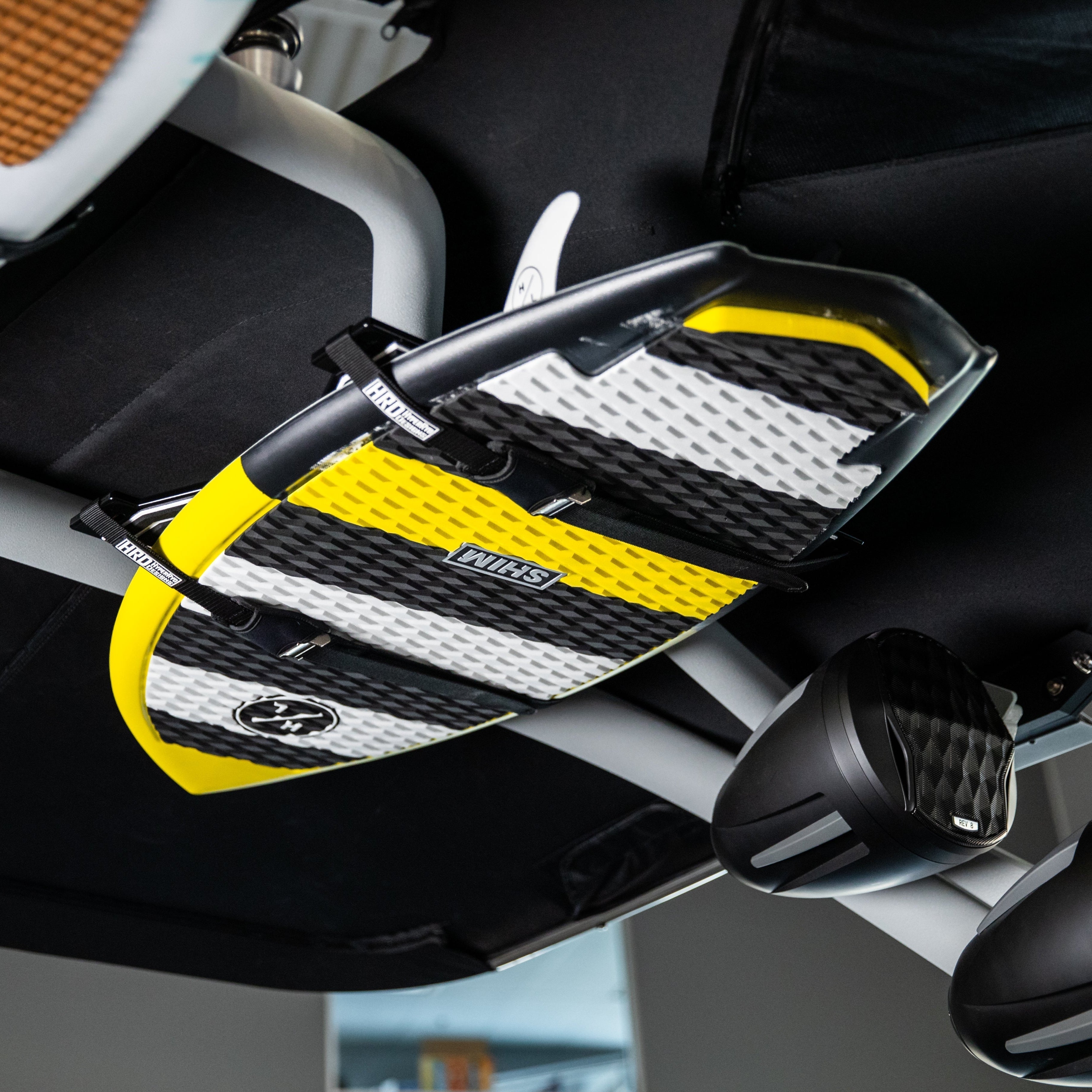 Surfboard secured on G3 & GV (G5)( towers with XR1 Surf Rack, featuring black, white, and yellow accents, mounted under vehicle roof.