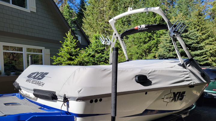 T22 Cover for FatAX Tower boat, gray protective cover with Wake Research logo, installed on a boat in a wooded outdoor setting.
