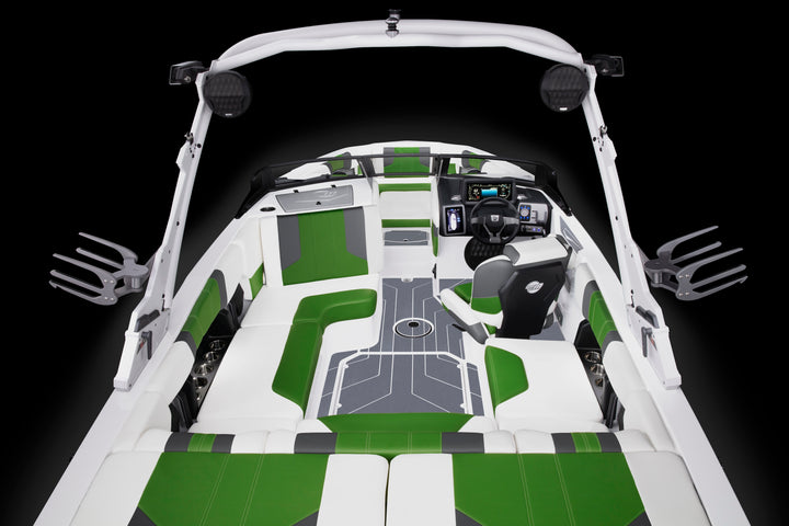 Interior view of a 21 LX Soft Grip Main Floor 22-24 boat with green and white cushioned seating, steering console, and fishing rod holders.