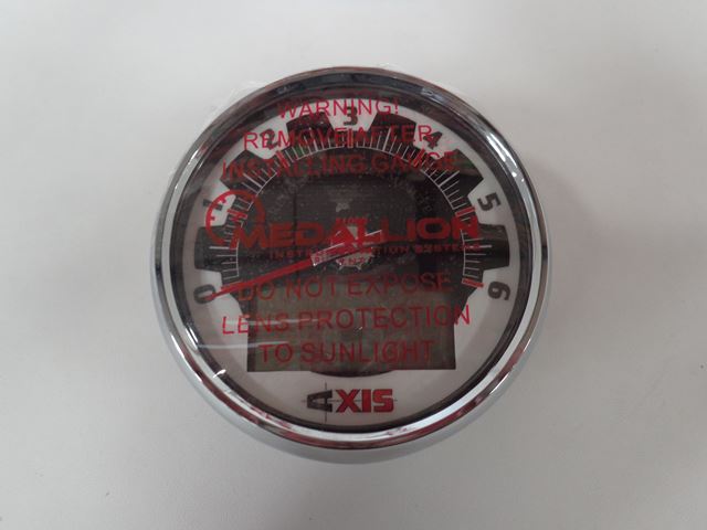 Round 5-inch axis tachometer gauge with black and white face, red warning text, and protective lens for vehicle engine RPM monitoring.
