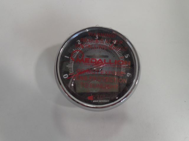Close-up of a Medallion Axis Tachometer with analog dial and digital display, used for measuring rotational speed.