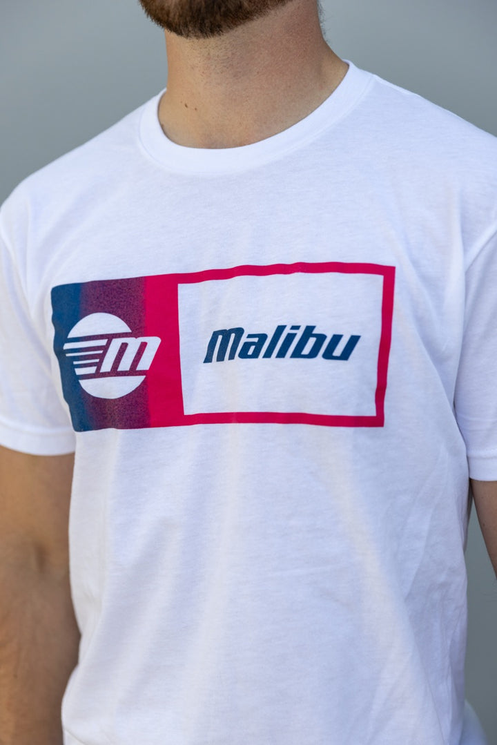 White Malibu Statement Tee featuring a bold, colorful graphic logo with "Malibu" text on the front.