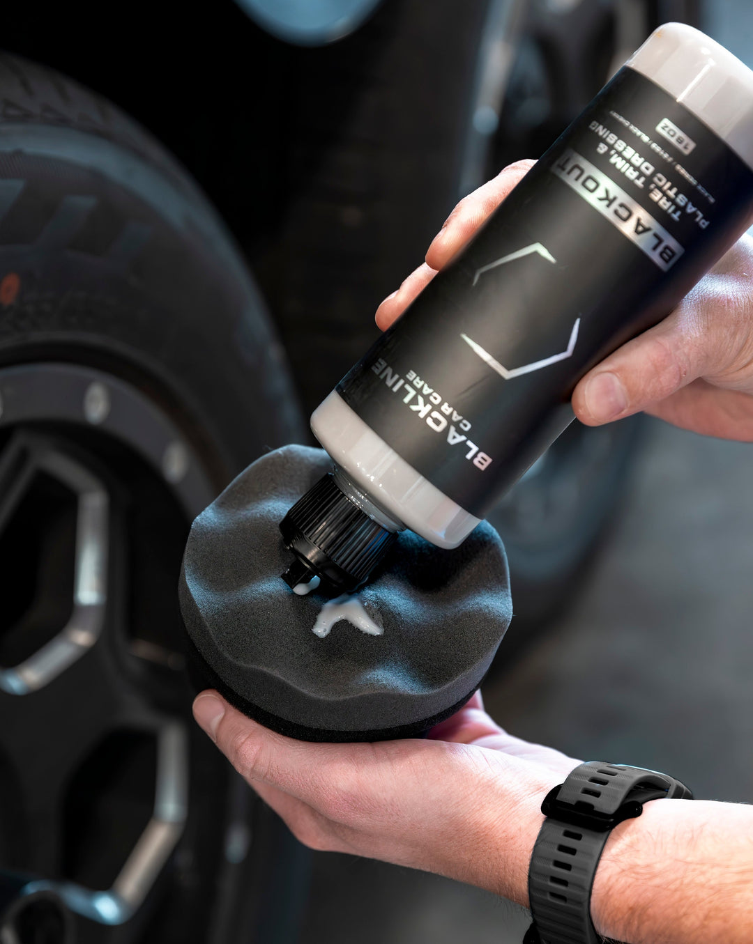 Applying Blackline Blackout Trim &amp; Tire Dressing to enhance vehicle trim and tires for a sleek, black finish.