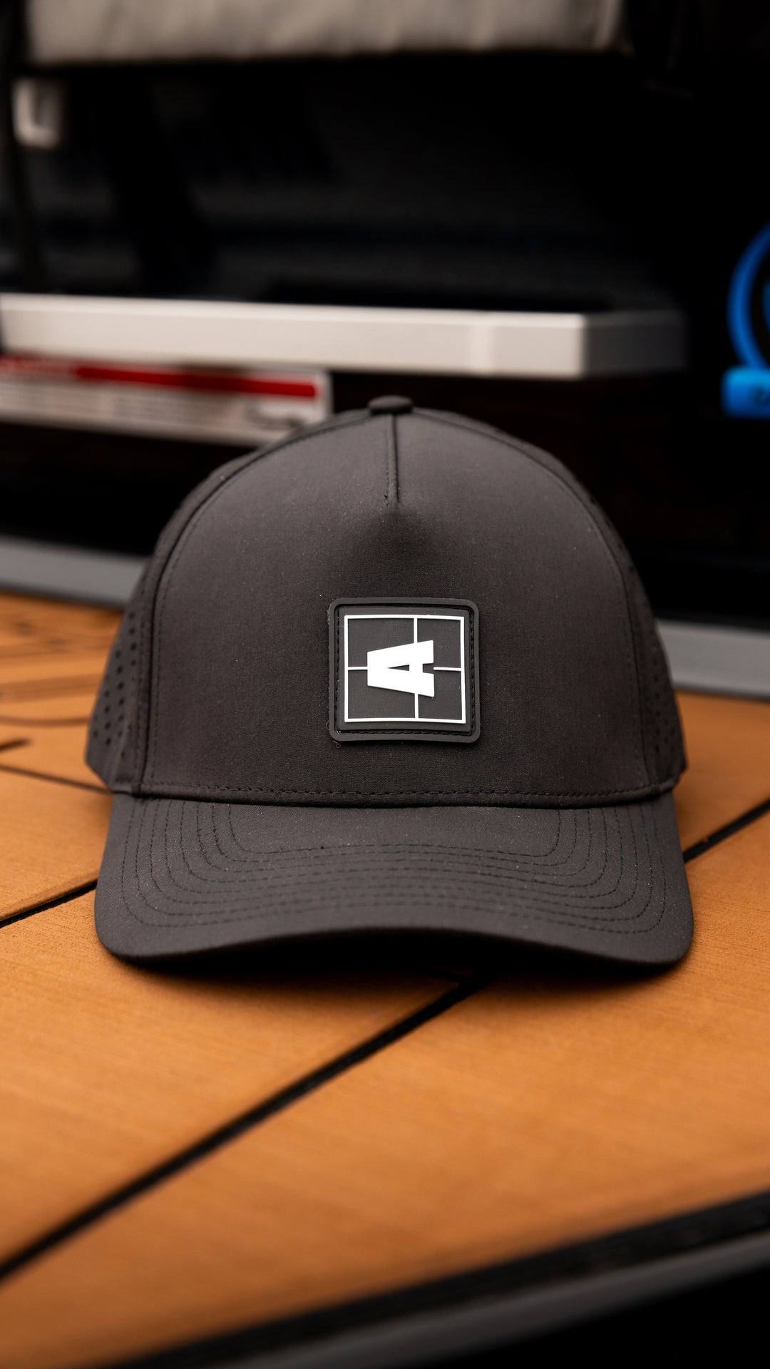Black Axis Swell Hat with a square logo patch featuring a white "A" on the front, mesh side panels, and curved brim.
