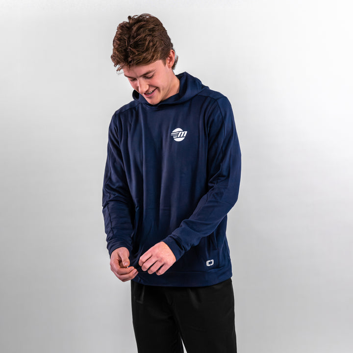 A young man wearing a navy Malibu Performance Hoodie, adjusting the cuffs with a smile, showcasing comfort and style.