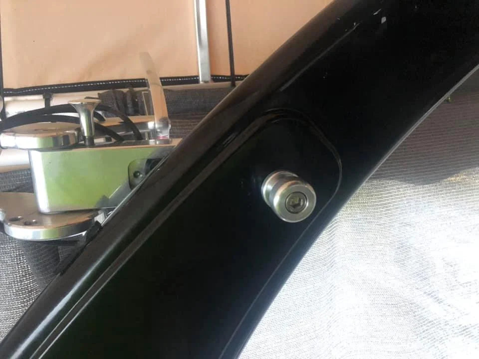 Close-up of surf tow points on Malibu W/illusion X tower, showing a black metal frame with a silver bolt.