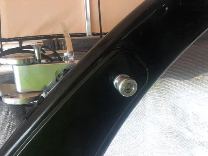Close-up of surf tow points on Malibu W/illusion X tower, showing a black metal frame with a silver bolt.