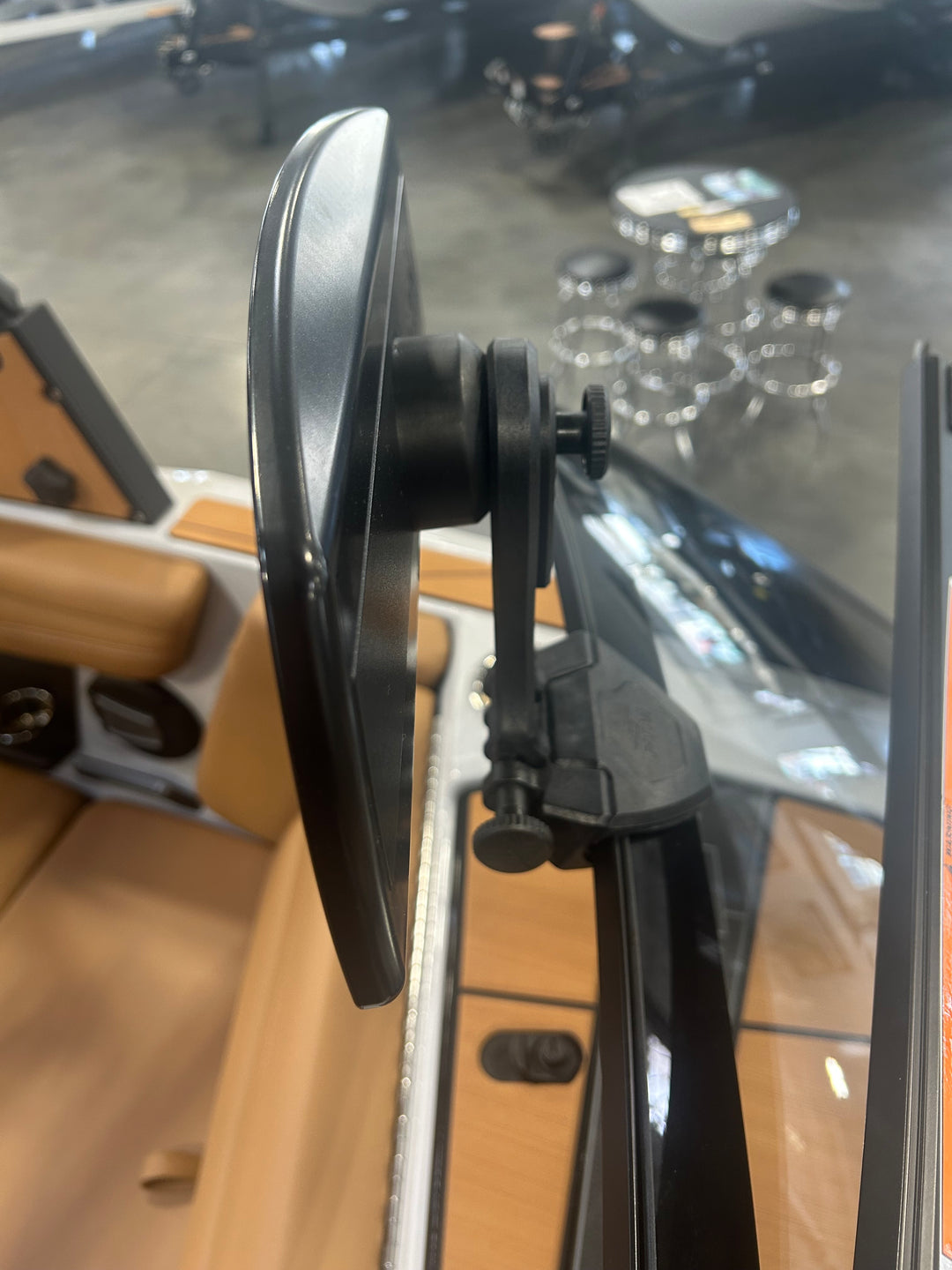 Close-up of the PTM Pro Mirror mounted on a vehicle dashboard, showing adjustable mounting mechanism and reflective surface.