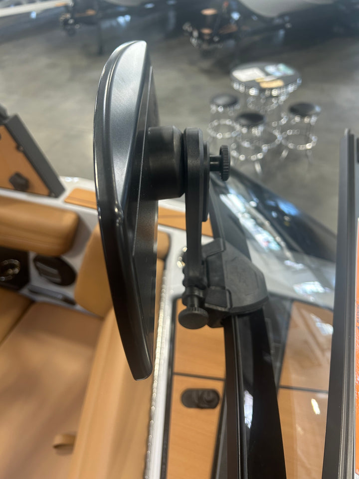 Close-up of the PTM Pro Mirror mounted on a vehicle dashboard, showing adjustable mounting mechanism and reflective surface.