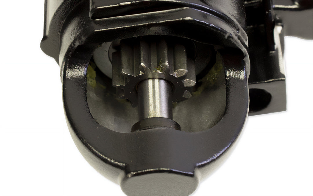 Close-up of a small and large block starter motor component, showing gear and shaft inside a black housing.