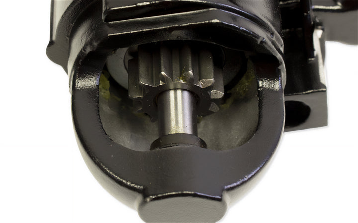 Close-up of a small and large block starter motor component, showing gear and shaft inside a black housing.