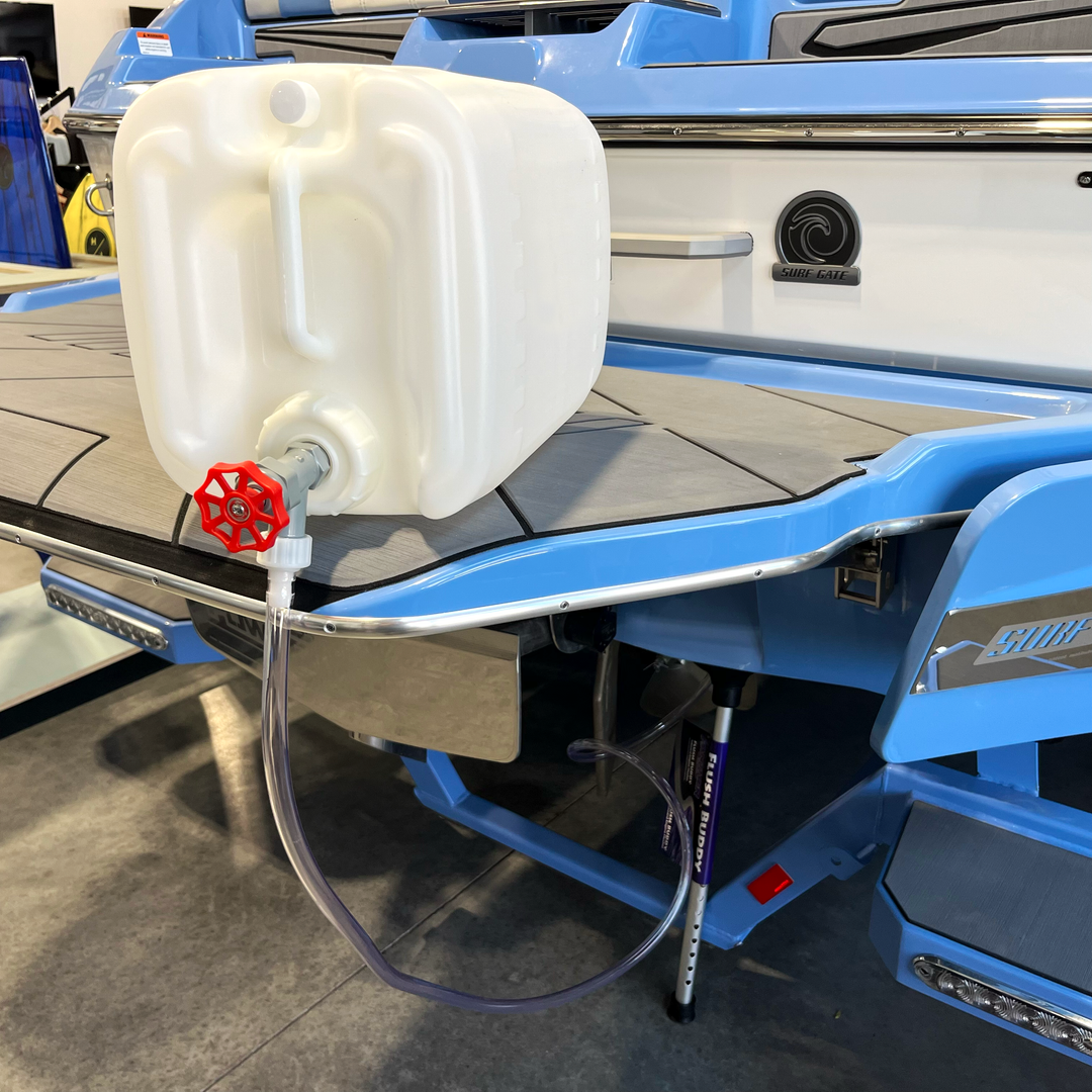 Winterizing kit for inboard boats, featuring a white container with a red valve, ready for maintenance on a blue boat.