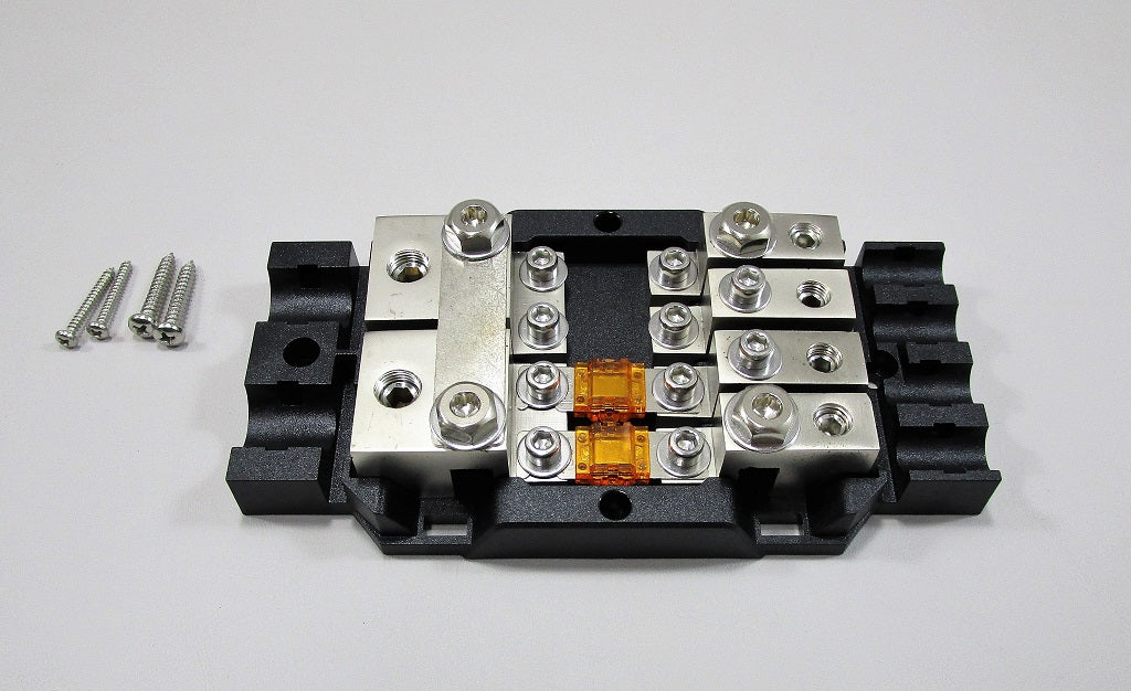 Malibu distribution block with metal terminals, screws, and orange fuses, used for electrical connections in marine or RV systems.
