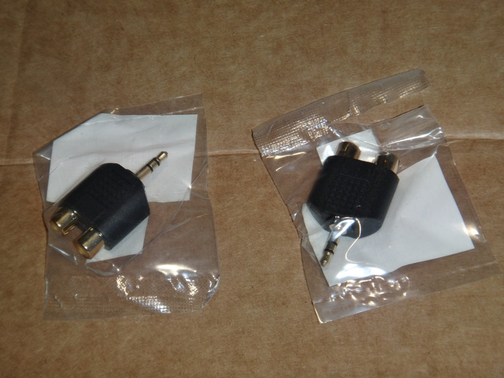 RCA stereo audio splitter adapter with one input and two output connectors, black plastic body, in sealed plastic packaging.