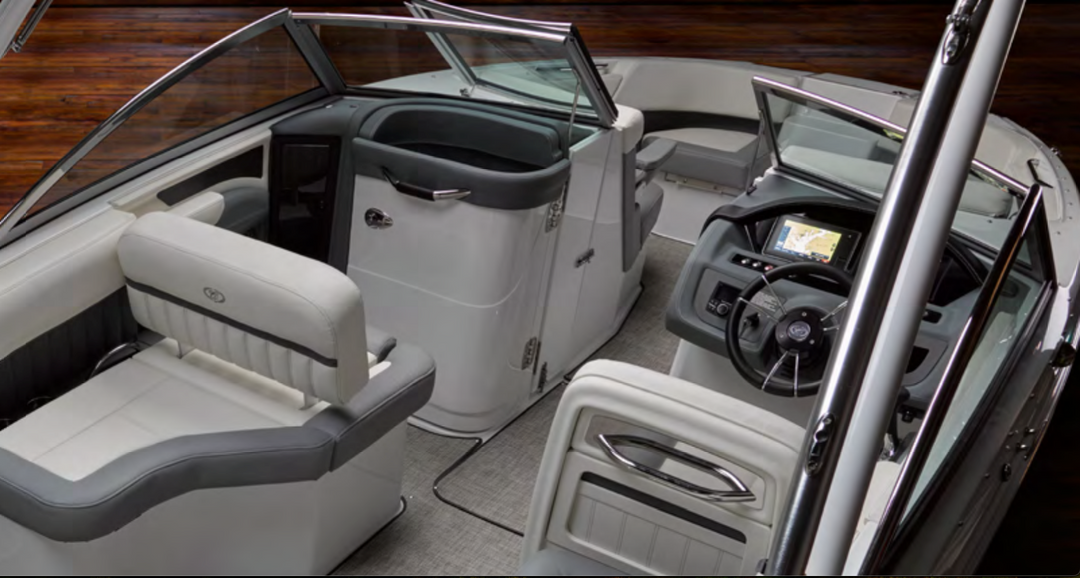 Interior view of a boat showcasing seating and dashboard, highlighting the glove box lock and keys for secure storage.