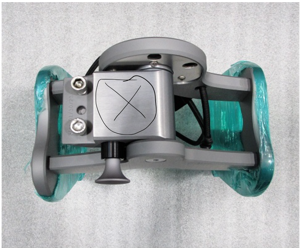Top-down view of the GV Spinner Pivot, a mechanical device with metal components, black wiring, and teal protective covers on sides.