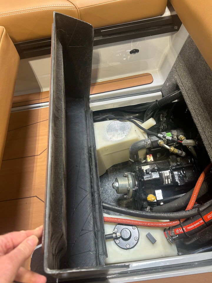 Close-up of an axis transmission cover removed, revealing internal mechanical components and wiring inside a boat or vehicle.
