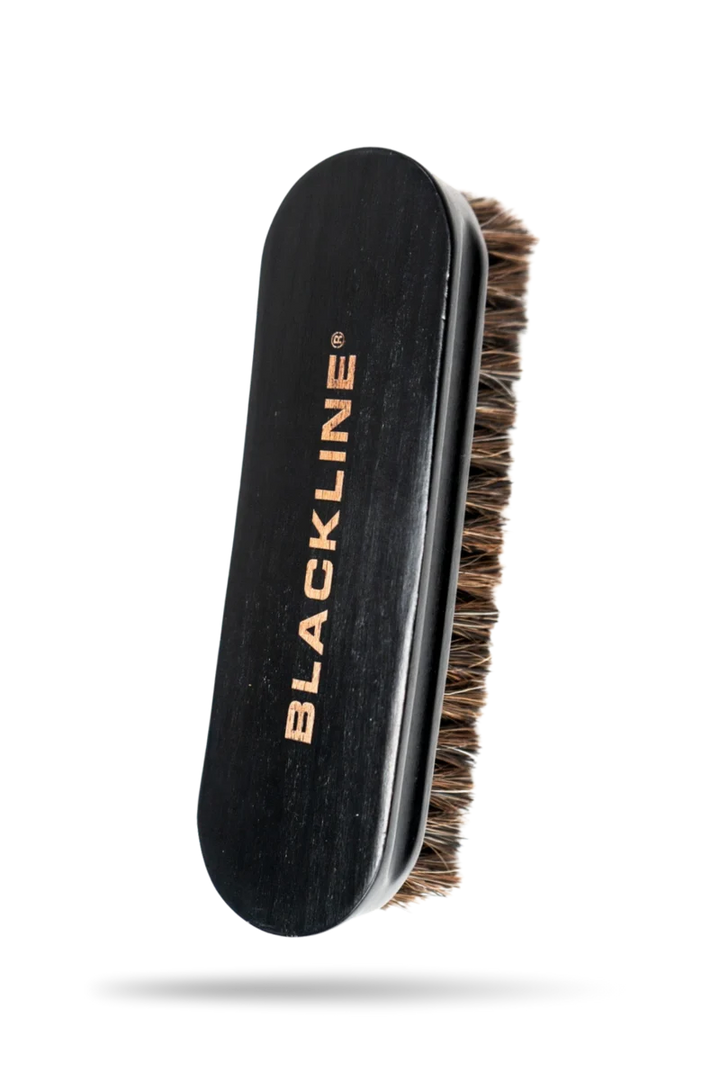 Leather brush with a wooden handle and soft bristles, designed for cleaning and maintaining leather goods.