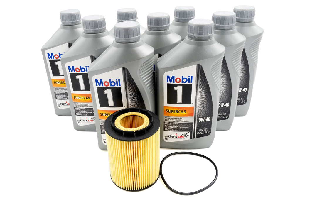 Six bottles of Mobil 1 Supercar 0W-40 synthetic motor oil, along with a yellow oil filter and a black O-ring gasket.