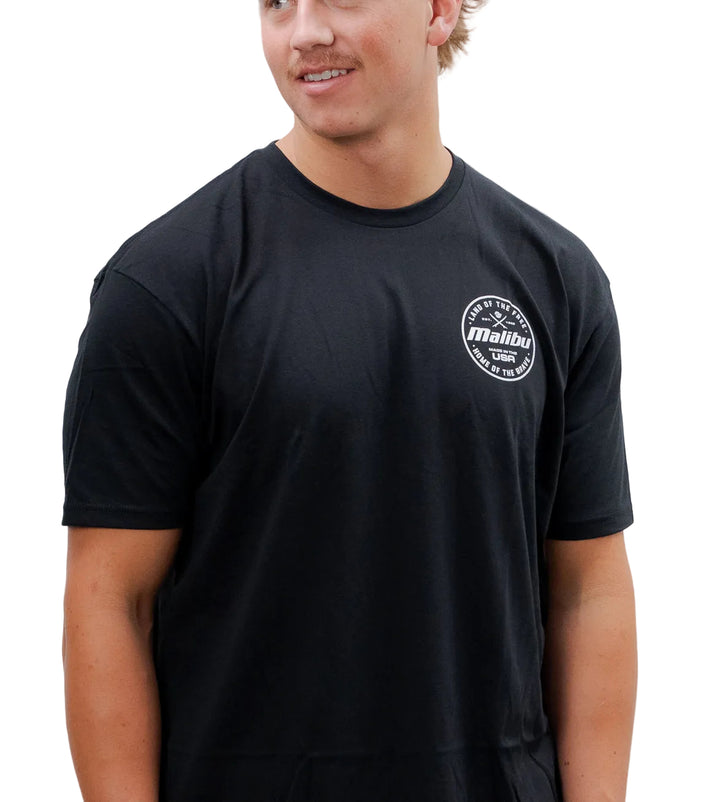 Black Malibu Brave T-shirt with a small white circular logo on the chest reading "Land of the Free, Made in the USA, Home of the Brave.