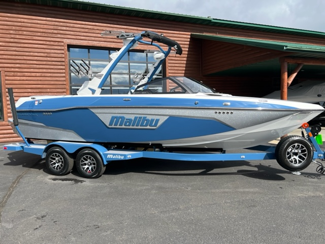 Decal emblem reading "Malibu 50 Nassau Blue" on a blue and white speedboat on a trailer.
