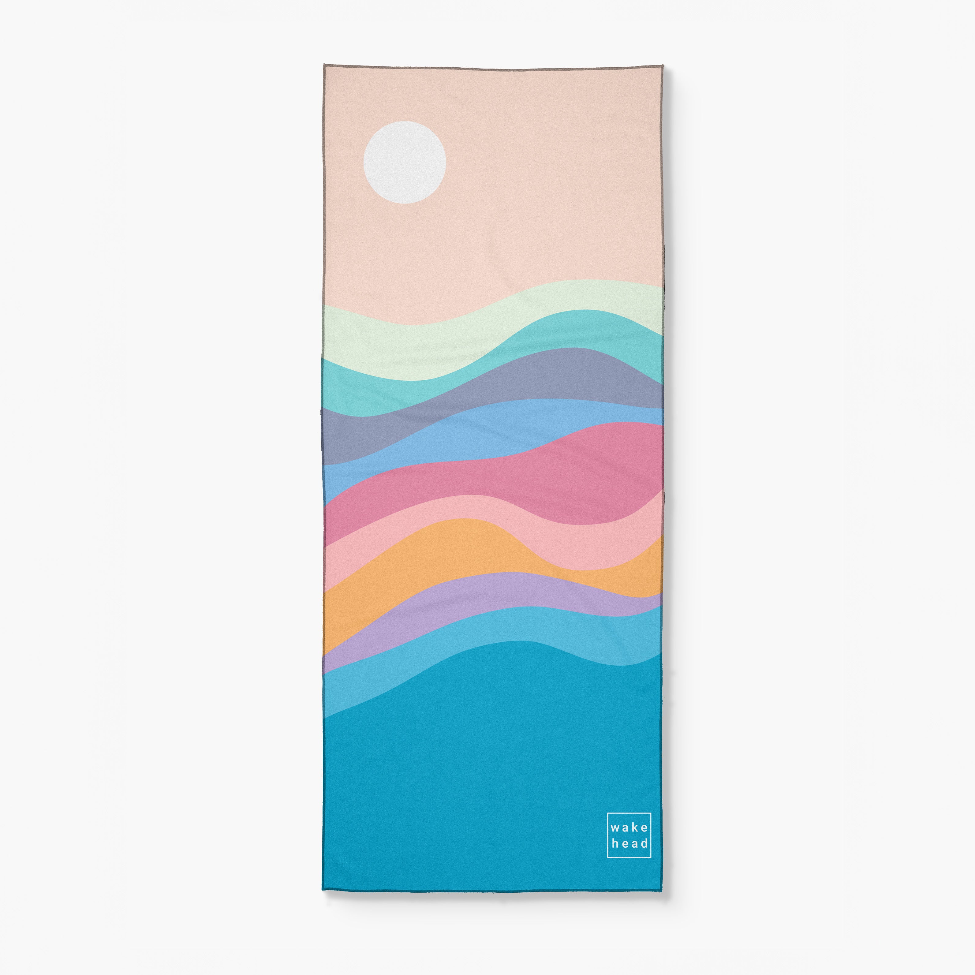 Pastel-colored lake-themed towel with wavy patterns and a small "wake head" logo at the bottom corner.