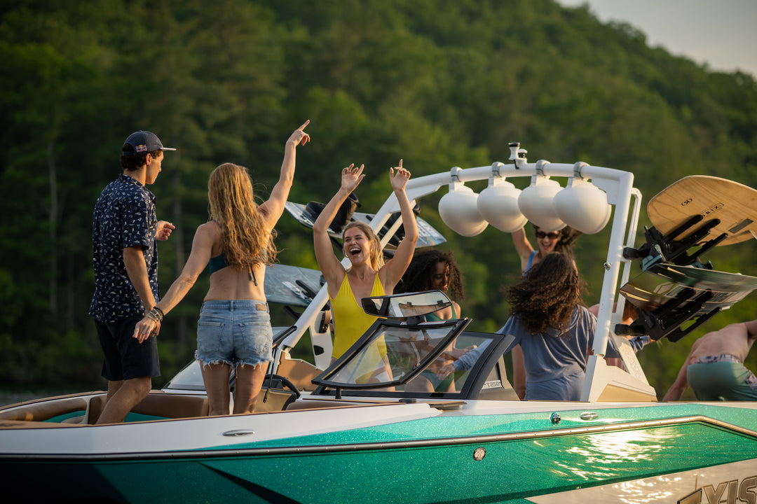 Axis AW20 Tower in white with excited friends enjoying a day on the water, showcasing a vibrant boating experience.