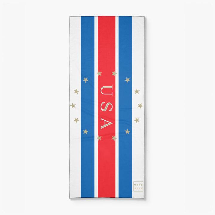 Stars and stripes lake towel with red, white, and blue vertical stripes, gold stars, and "USA" text in the center.