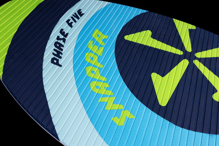 Close-up of the 2025 Phase 5 Snapper Skim Board featuring a blue, white, and neon yellow design with textured surface and bold branding.