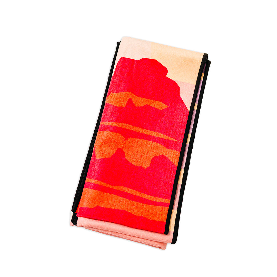 Powell Wake Head towel with a vibrant, abstract red and orange landscape design, folded on a white background.