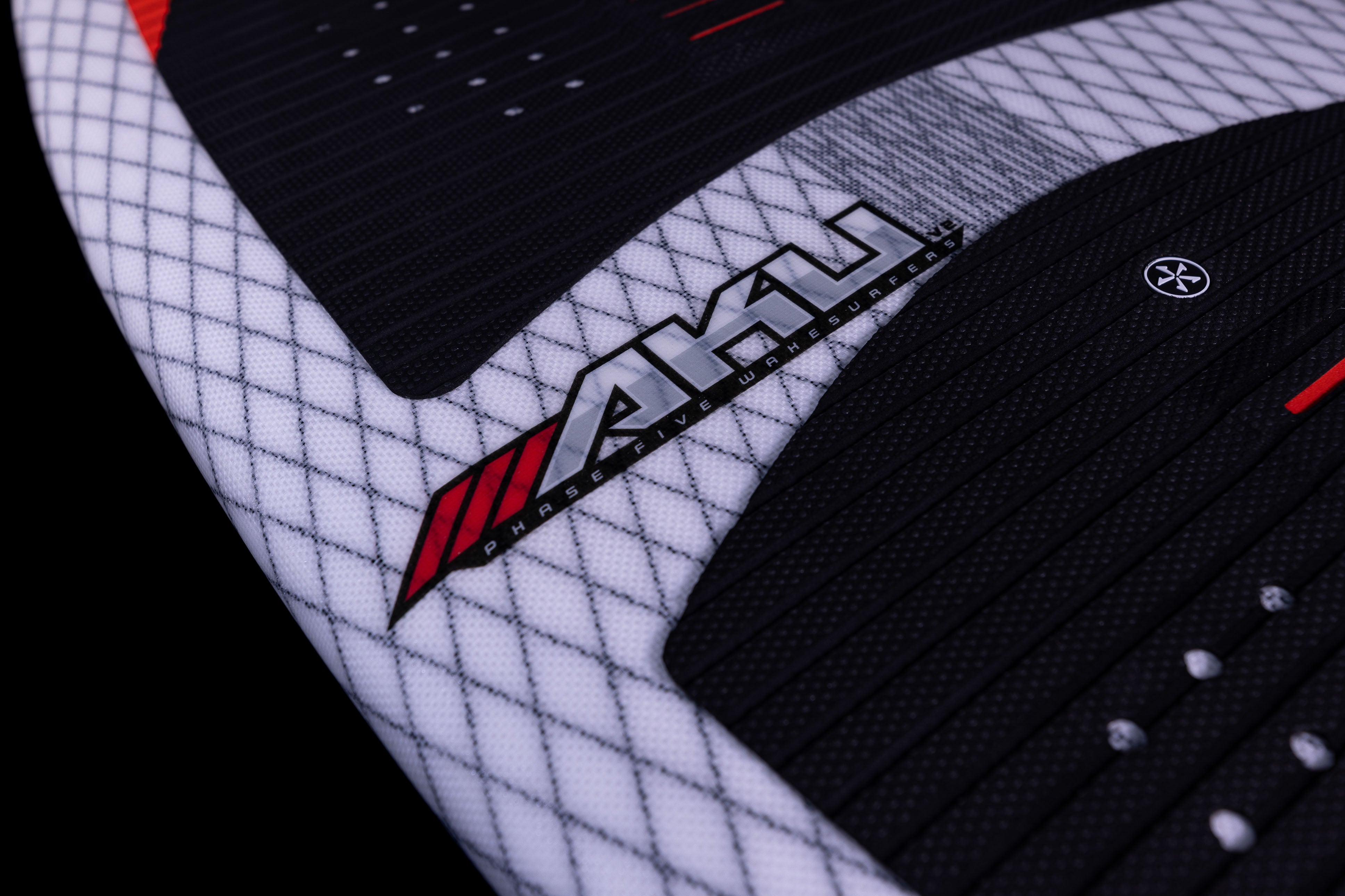 Close-up of the 2025 Phase 5 Aku Surf Board featuring a black, white, and red design with textured grip pads and the brand logo.