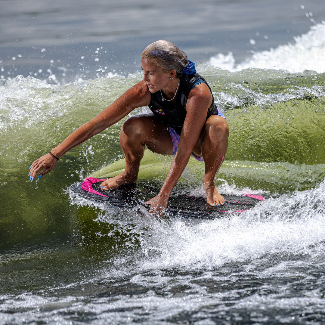 A person rides the 2026 Phase Five Diamond Luv surfboard on a wave, showcasing skill and balance in water sports.