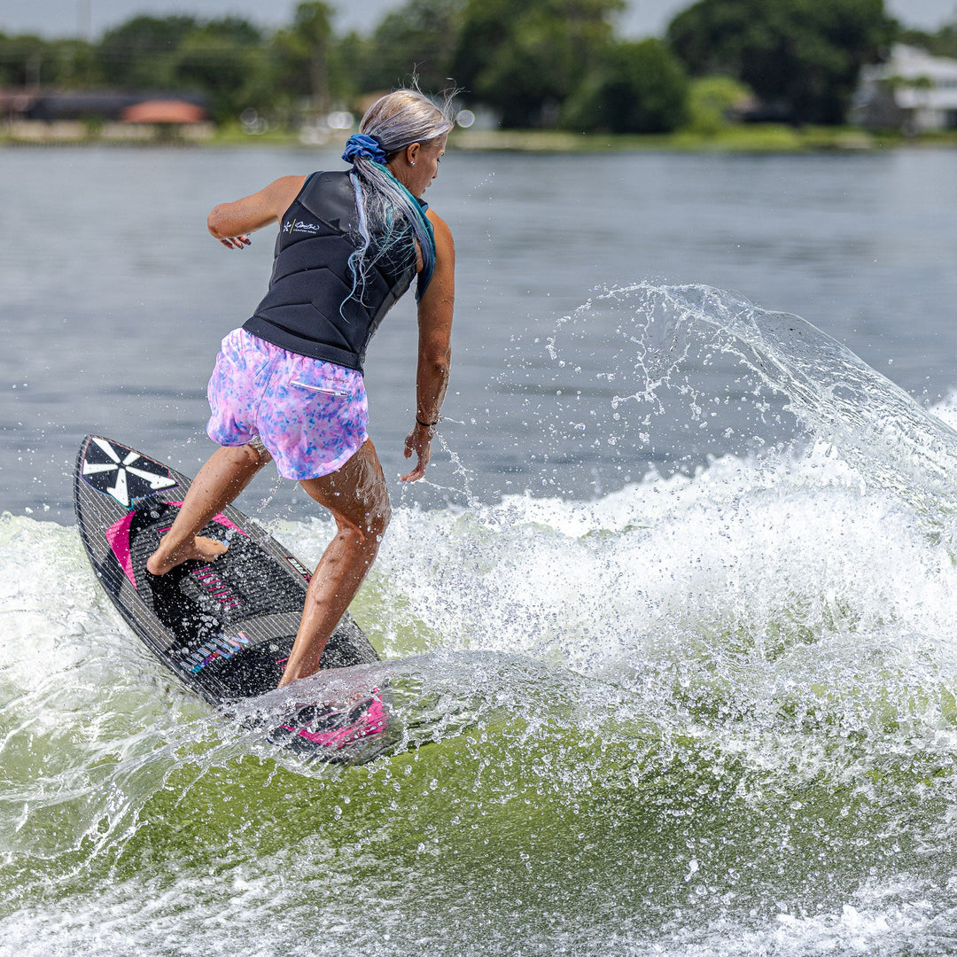 A person rides the 2026 Phase Five Diamond Luv surfboard, carving through a wave on a sunny day.