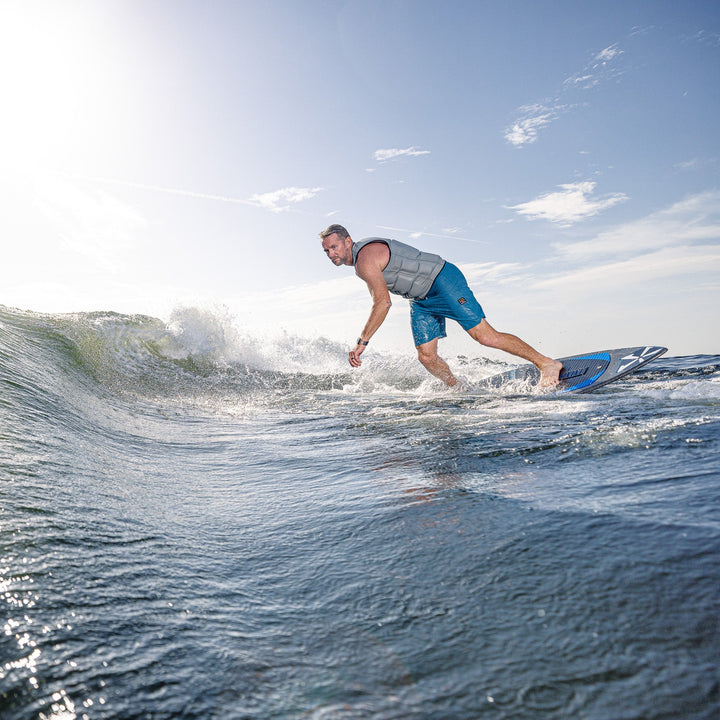 A surfer rides a wave on the 2026 Phase Five Diamond Turbo, showcasing its performance and design in action.