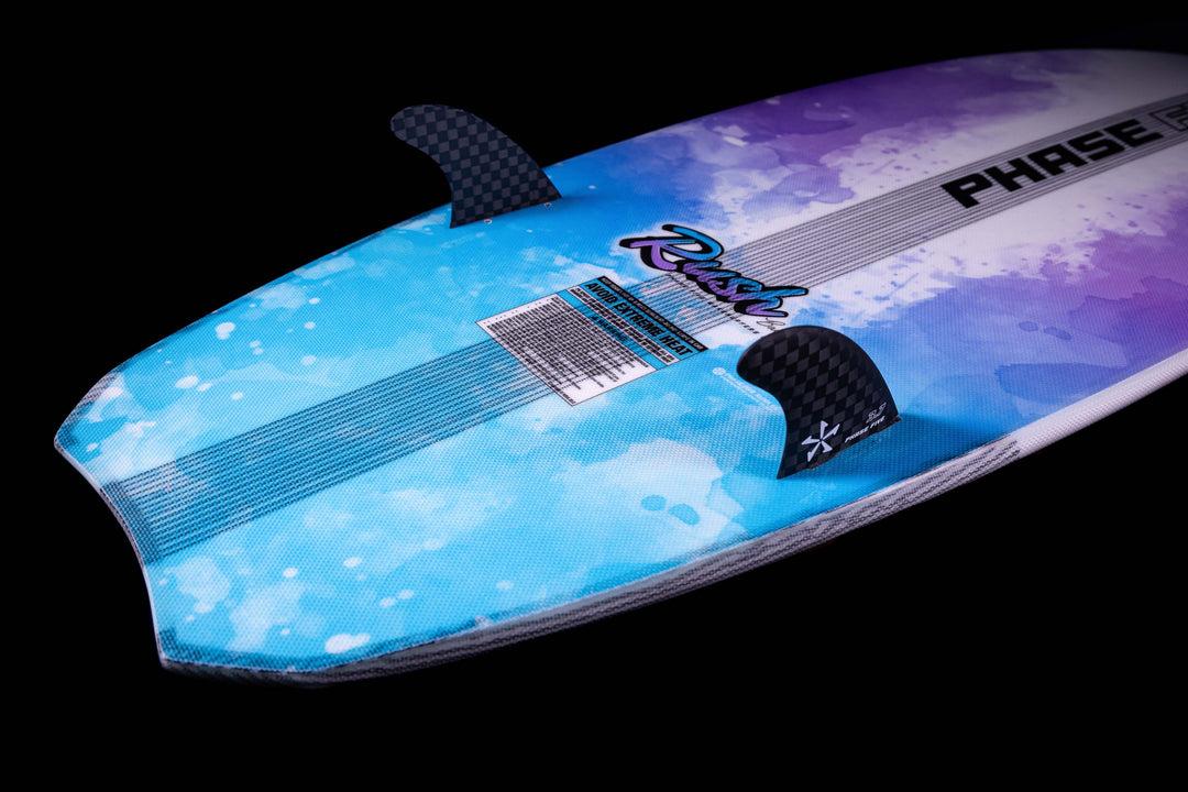 2025 Phase 5 Rush surfboard with a blue and purple splash design, featuring carbon fiber fins and a textured deck.