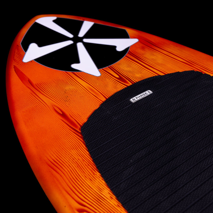 Close-up of the 2025 Phase 5 Fish Skim Board featuring an orange design and textured black traction pad.